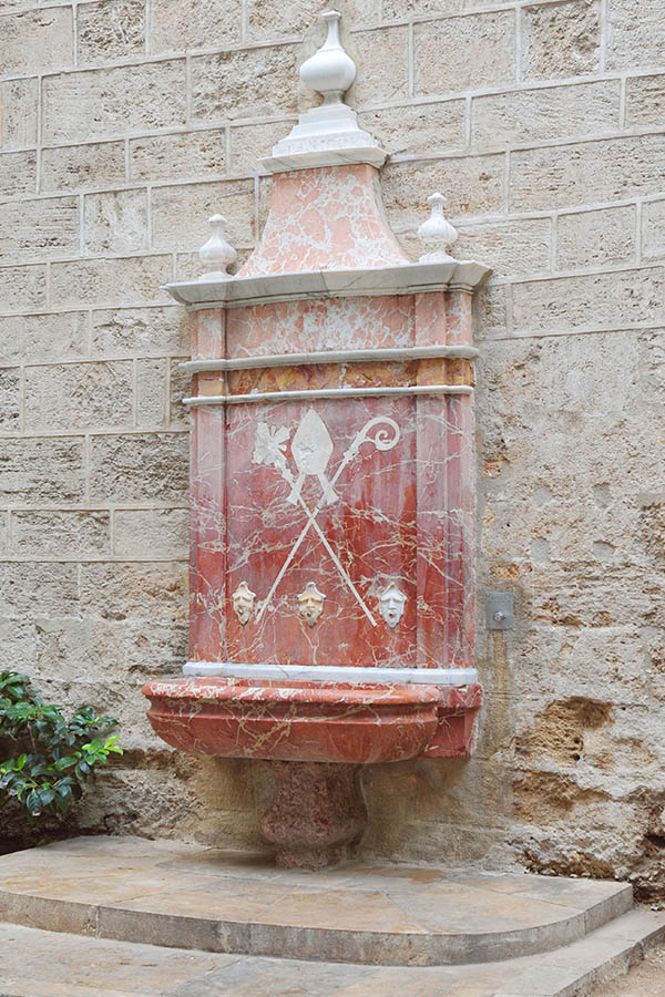 Medieval-red marble-drinking-fountain-in a church wall-Valencia-Spain
