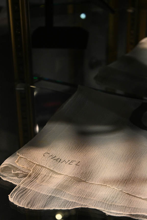 A-sheer-light-colored-Chanel-scarf-with-a-crinkled-texture-is-displayed