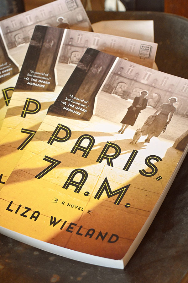 book-cover-for-the-novel-Paris-7am-by-Liza-Wieland-with-a-yellow-cover-featuring-a-black-and-white-photo-of-two-women-on-a-Parisian-street