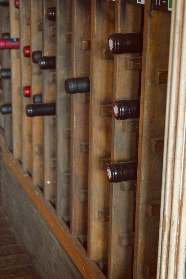rustic-wooden-wine-rack-that-appears-to-be-a-type-of-riddling-rack-filled-with-multiple-bottles-of-wine