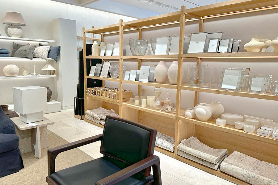 Minimalist-interior-design-display-featuring-light-wood-shelving-filled-with-neutral-toned-vases-picture-frames-and-candles