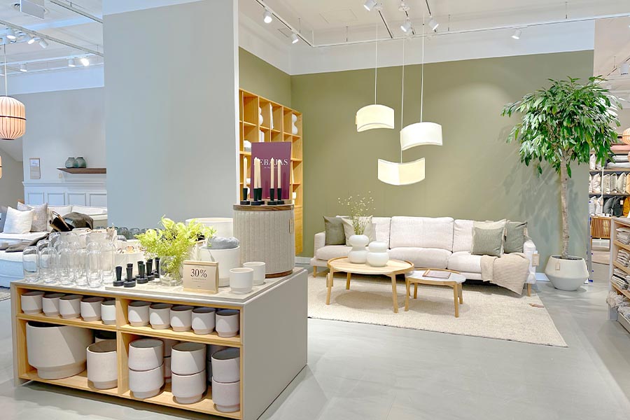 Modern-home-decor-store-featuring-a-white-sofa-sage-green-wall-and-minimalist-ceramic-pottery-displays