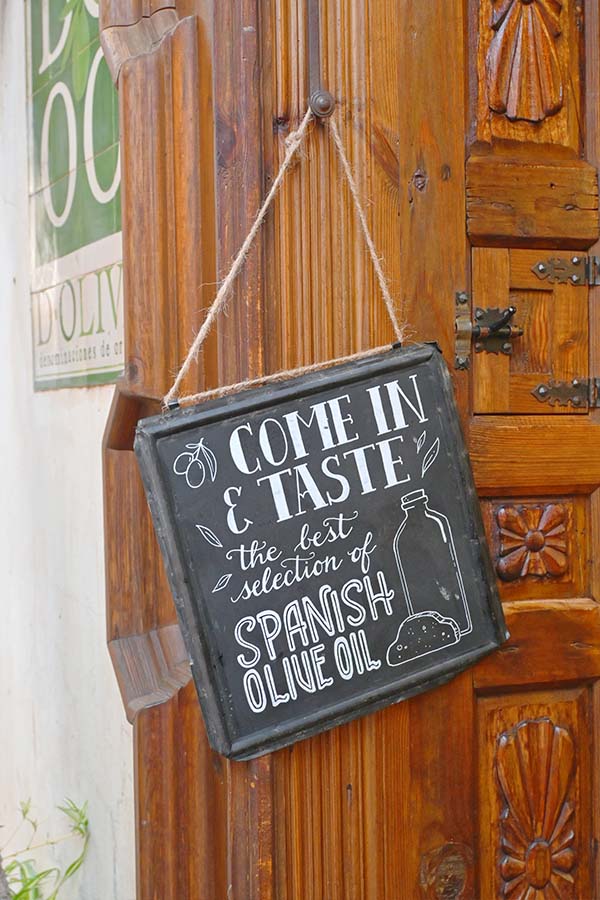 black-chalkboard-sign-on-an-ornate-wooden-door-reads-COME-IN-AND-TASTE