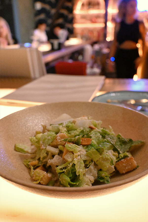 fresh-caesar-salad-with-crispy-croutons-and-shaved-parmesan-cheese-is-served-in-a-textured-tan-bowl-serafina-miami