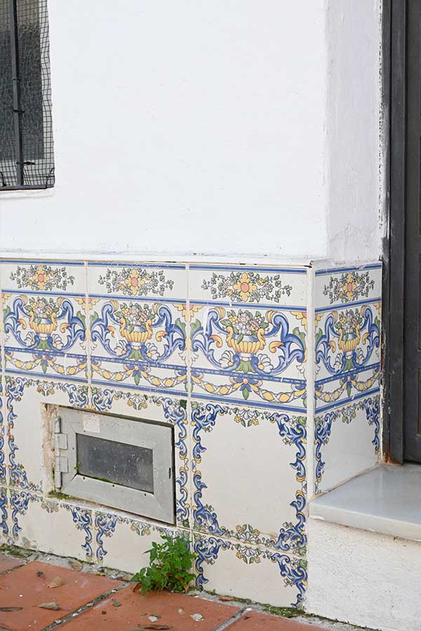 white-exterior-wall-is-decorated-with-ornate-blue-yellow-and-green-floral-ceramic-tiles