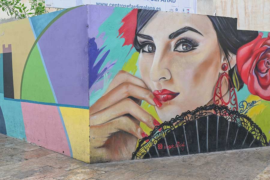 Close-up-of-a-street-mural-depicting-a-woman-with-a-red-rose-and-lace-fan