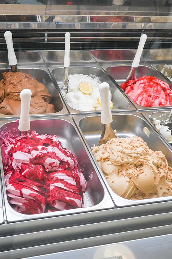 Close-up-view-of-various-colorful-gelato-flavors-displayed-in-metal-containers
