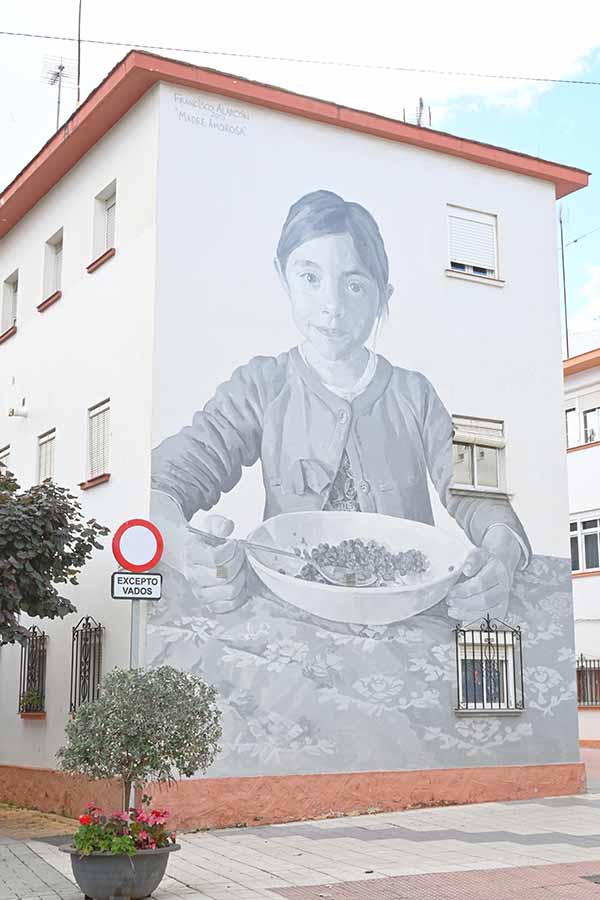 Large-grayscale-mural-of-a-smiling-child-eating-from-a-bowl-estepona-spain