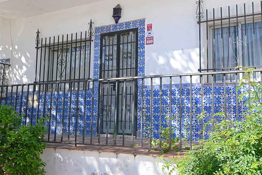 Large-terrace-with-black-metal-railings-and-extensive-blue-and-white-floral-wall-tiling