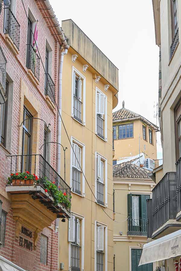 Narrow-street-view-featuring-colorful-apartment-buildings-with-wrought-iron-balconies