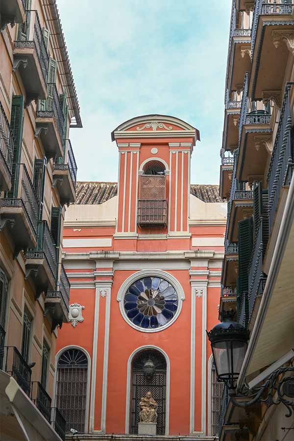 Peach-colored-church-facade-with-a-large-round-stained-glass-window