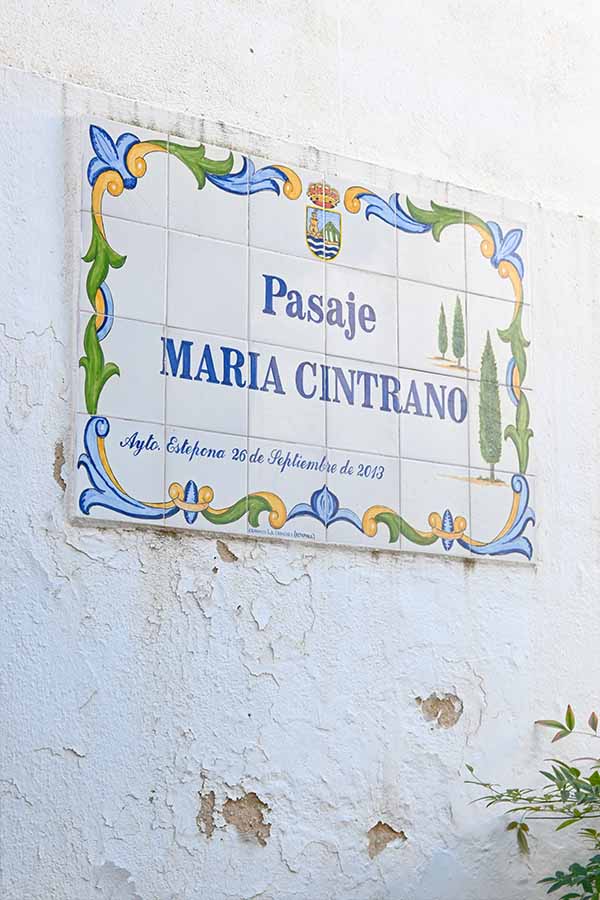 Rectangular-tile-plaque-on-a-weathered-white-wall-reading-Pasaje-Maria-Cintrano-Estepona-spain