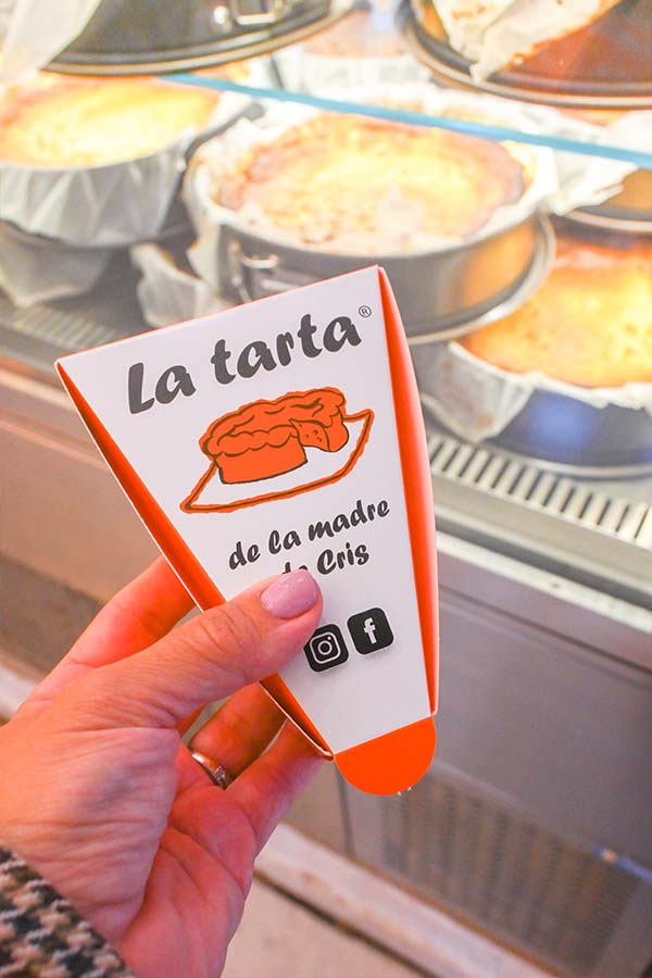 holding-a-small-triangular-white-and-orange-box-with-a-cake-illustration