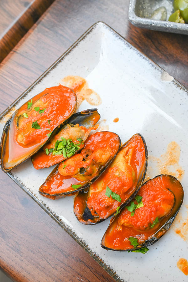 steamed-mussels-tomato-sauce-fresh-parsley-white-rectangular-plate-seafood-tapas-appetizer-spanish-cuisine
