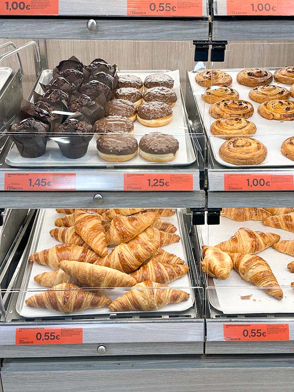 Bakery-shelves-filled-with-muffins-glazed-donuts-raisin-swirls-and-golden-croissants