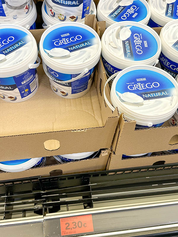 Large-tubs-of-natural-Greek-yogurt-stacked-in-cardboard-boxes