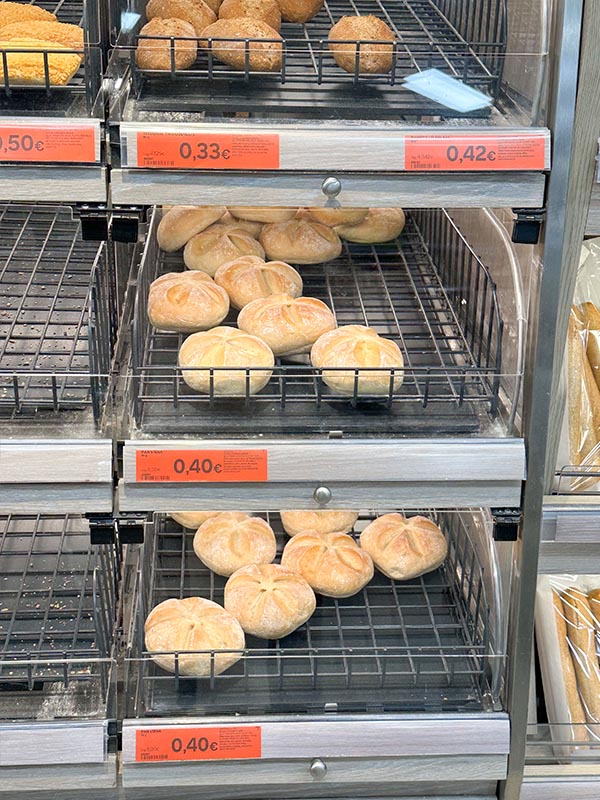 Shelved-loaves-of-gluten-free-bread-molletes-and-seeded-whole-grain-options-in-plastic-packaging