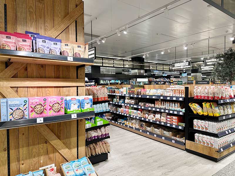Wooden-shelves-stocked-with-bags-of-granola-and-cereal-boxes