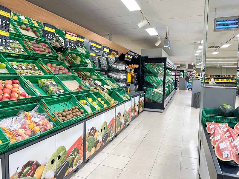 produce-aisle-with-crates-of-apples-kiwis-and-melons
