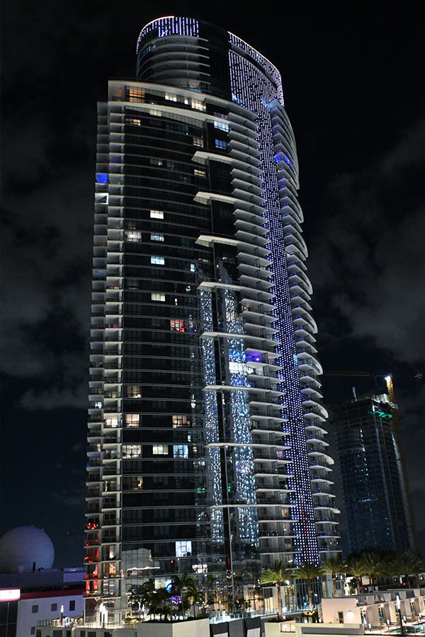 The-Paramount-Worldcenter-luxury-tower-displaying-its-signature-vertical-LED-lighting-strips-under-the-Miami-architecture-moonlight