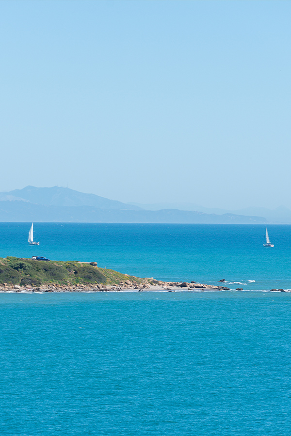 The-Rock-of-Gibraltar-featured-in-this-view-of-sailboats-passing-a-rocky-outcrop-into-the-ocean