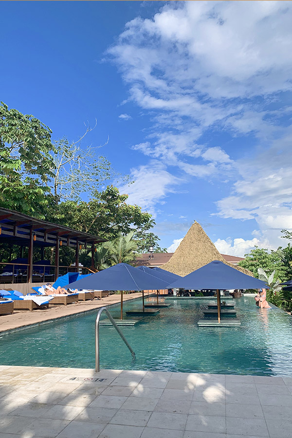 Tropical-swimming-pool-blue-umbrellas-Costa-Rica-sunny-skies