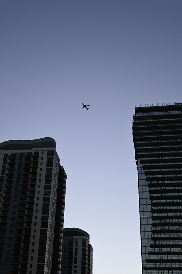 minimalist-shot-of-an-airplane-flying-between-the-silhouette-of-two-massive-residential-towers-in-Miami-Architecture