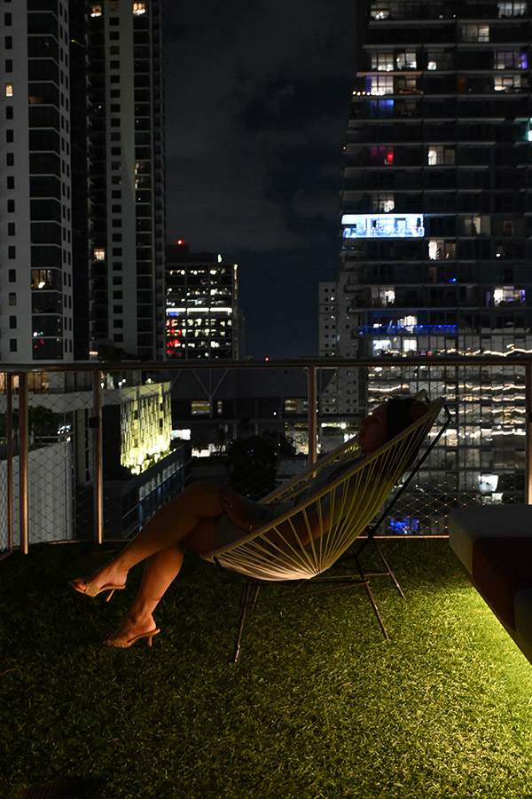 rooftop-garden-view-of-the-Miami-architecture-skyline-featuring-a-person-relaxing-in-an-Acapulco-chair