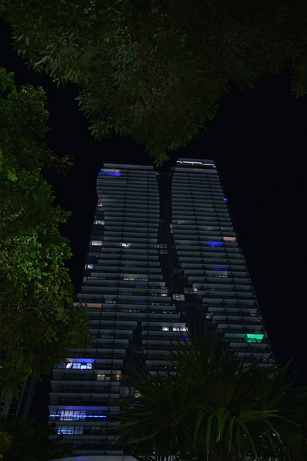 symmetrical-night-shot-of-glowing-apartment-terraces-rising-into-the-dark-sky-of-Miami-Architecture