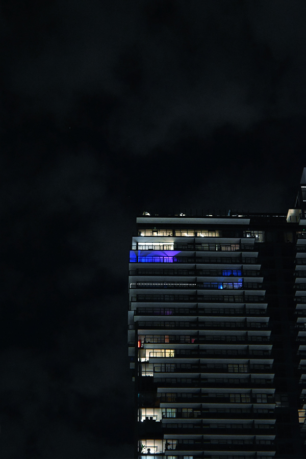 upper-tiers-of-a-modern-Miami-architecture-high-rise-with-striking-blue-and-purple-ambient-lighting-on-the-penthouses
