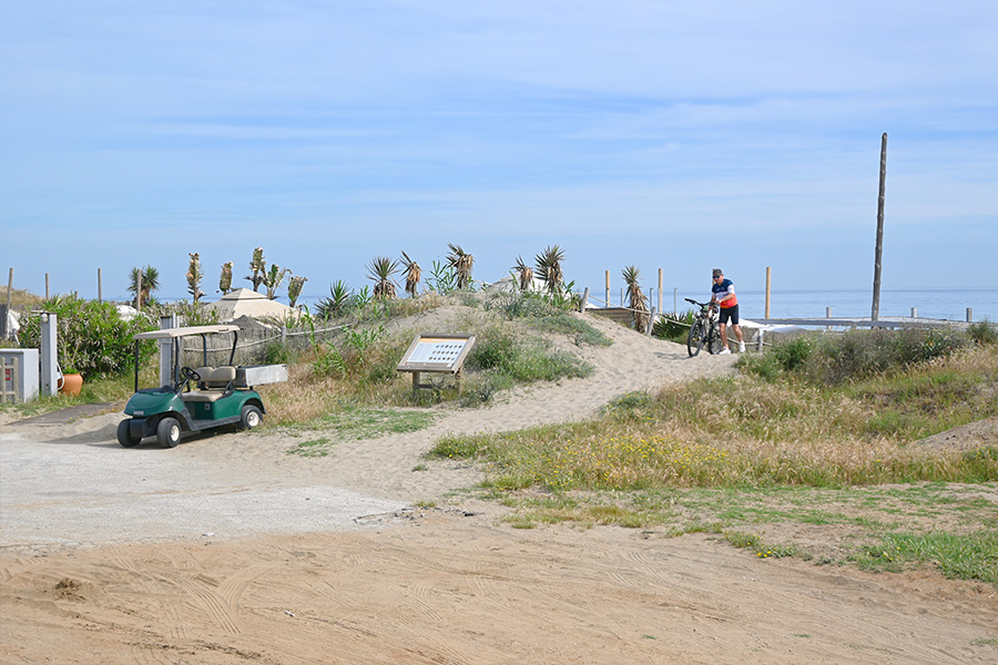 golf-cart-parked-near-the-dunes-at-Spain-best-beaches-Real-de-la-Zaragoza-with-a-cyclist-passing