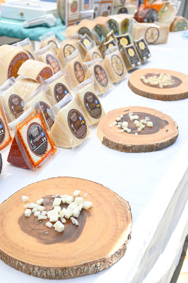 outdoor-market-stall-displaying-various-packaged-wedges-of-spanish-cheese