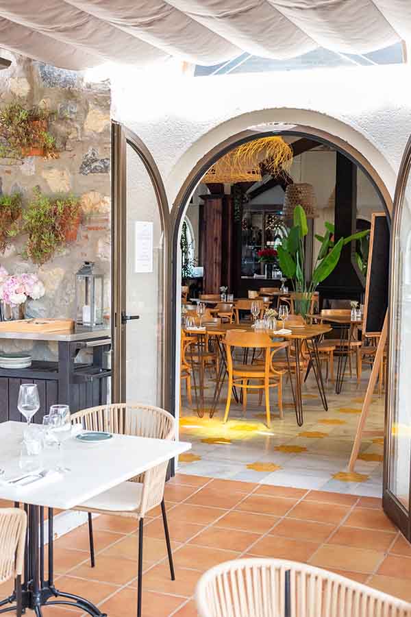 bright-outdoor-dining-terrace-view-into-an-indoor-restaurant-with-wooden-tables-at-hotel-castillo-de-monda-spain