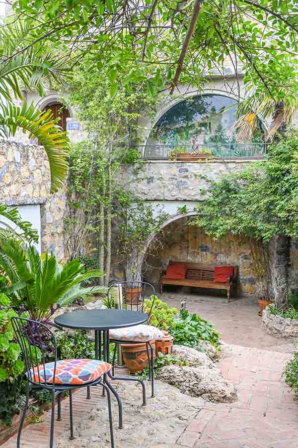 charming-stone-courtyard-patio-with-metal-garden-furniture-at-hotel-castillo-de-monda-spain