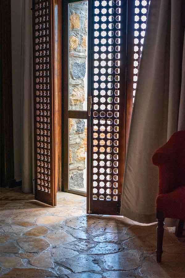 elegant-carved-wooden-screen-doors-opening-to-balcony-showing-classic-castle-design