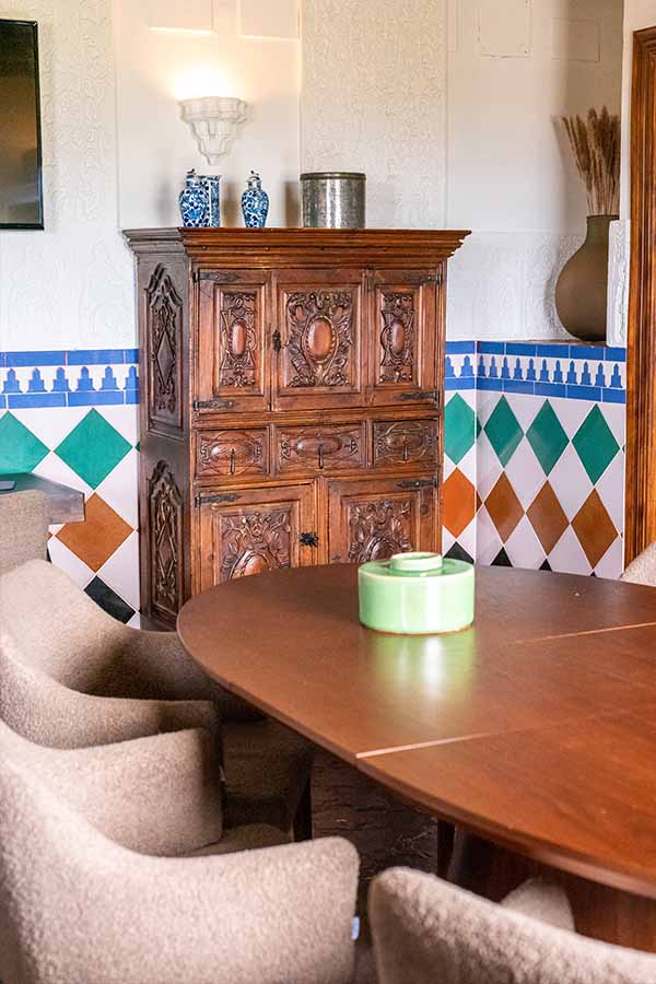 elegant-dining-room-with-carved-wooden-cabinet-and-colorful-wall-tiles-at-hotel-castillo-de-monda-spain