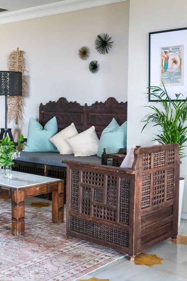 exotic-carved-wooden-sofa-with-light-blue-pillows-providing-unique-interior-design-inspiration