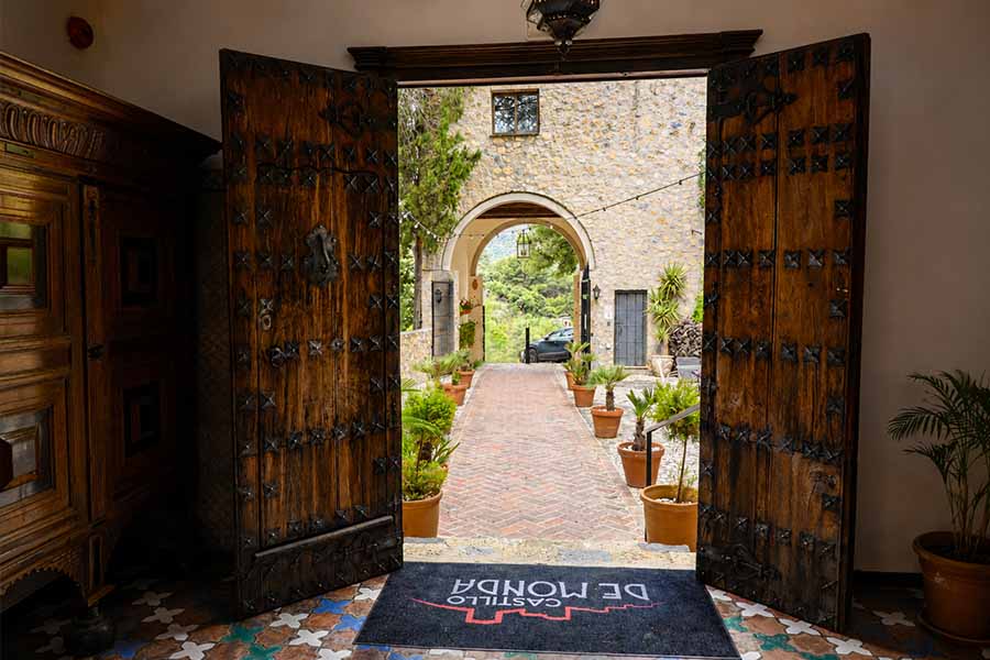 grand-open-wooden-castle-doors-leading-to-courtyard-at-hotel-castillo-de-monda-spain