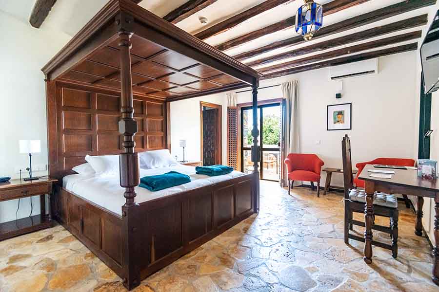 grand-wooden-four-poster-bed-in-historic-room-at-hotel-castillo-de-monda-spain