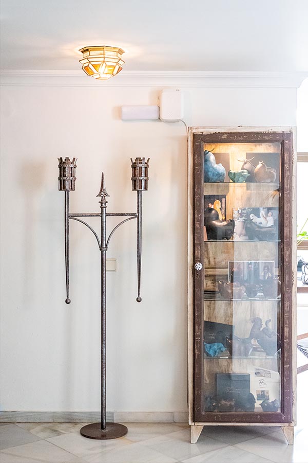 medieval-style-iron-candelabra-and-rustic-glass-display-cabinet-at-hotel-castillo-de-monda-spain