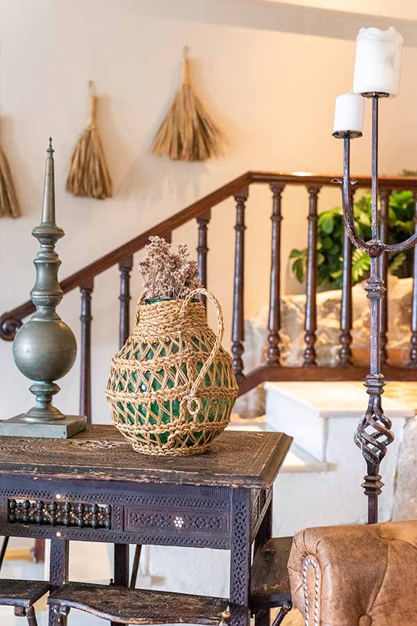 rustic-wooden-table-with-wicker-wrapped-bottle-and-metal-candelabra-offering-interior-design-inspiration