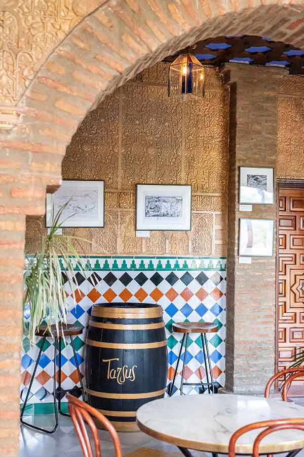 vibrant-spanish-tiled-wall-and-rustic-wine-barrel-table-at-hotel-castillo-de-monda-spain