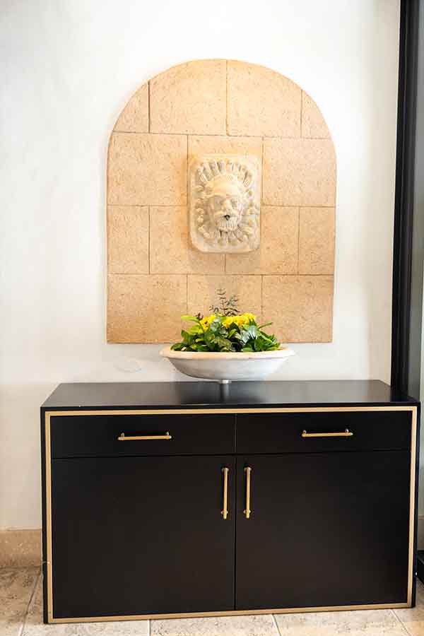 Black-credenza-gold-trim-stone-wall-sculpture-hotel-claude-marbella-spain-interior-design-boutique-hotel-design