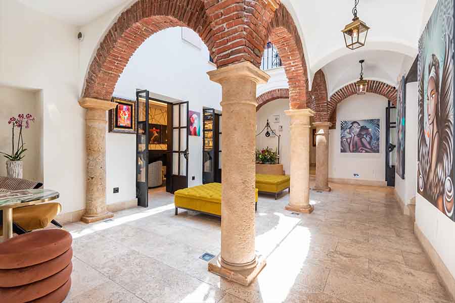 Courtyard-lobby-stone-columns-brick-arches-art-paintings-hotel-claude-marbella-spain-interior-design-boutique-hotel-design