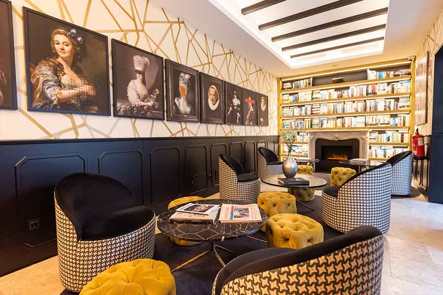 Lounge-library-fireplace-bookshelf-art-wall-houndstooth-chairs-hotel-claude-marbella-spain-interior-design-boutique-hotel-design