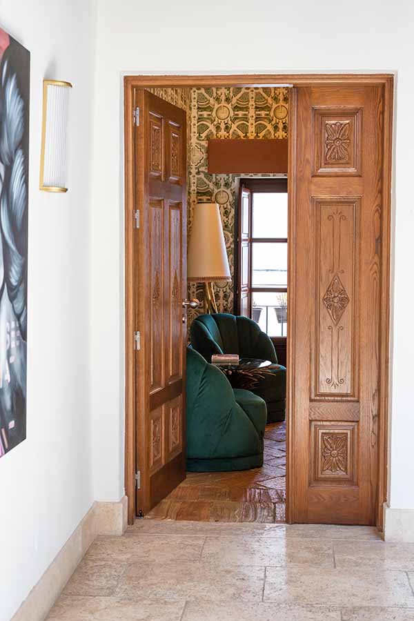 Open-wooden-doors-view-into-suite-green-velvet-chairs-hotel-claude-marbella-spain-interior-design-boutique-hotel-design