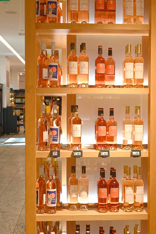 bottles-of-french-rose-wine-displayed-on-wooden-shelves-at-la-grande-epicerie-de-paris