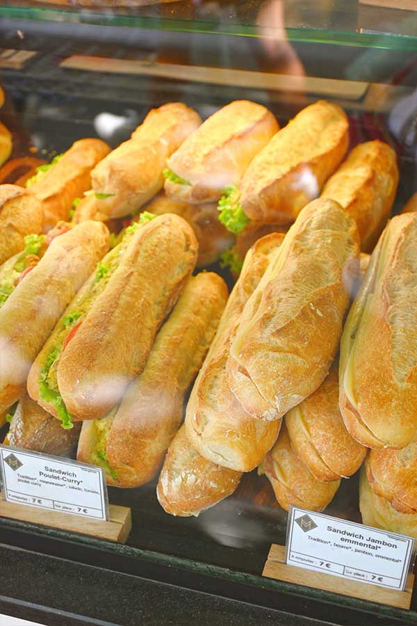 freshly-made-french-baguette-sandwiches-stuffed-with-poulet-curry-and-jambon-emmental-on-display-in-a-paris-boulangerie