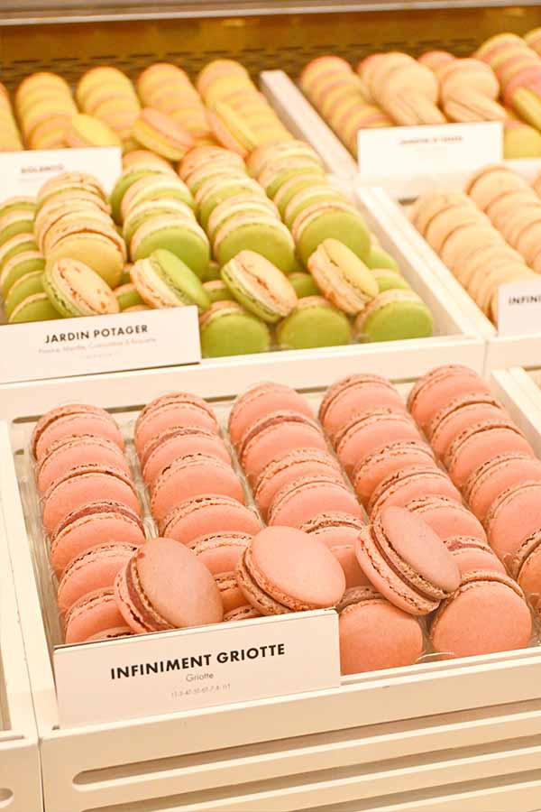 neatly-arranged-rows-of-colorful-french-macarons-including-cherry-and-pistachio-flavors-in-a-pastry-shop-display