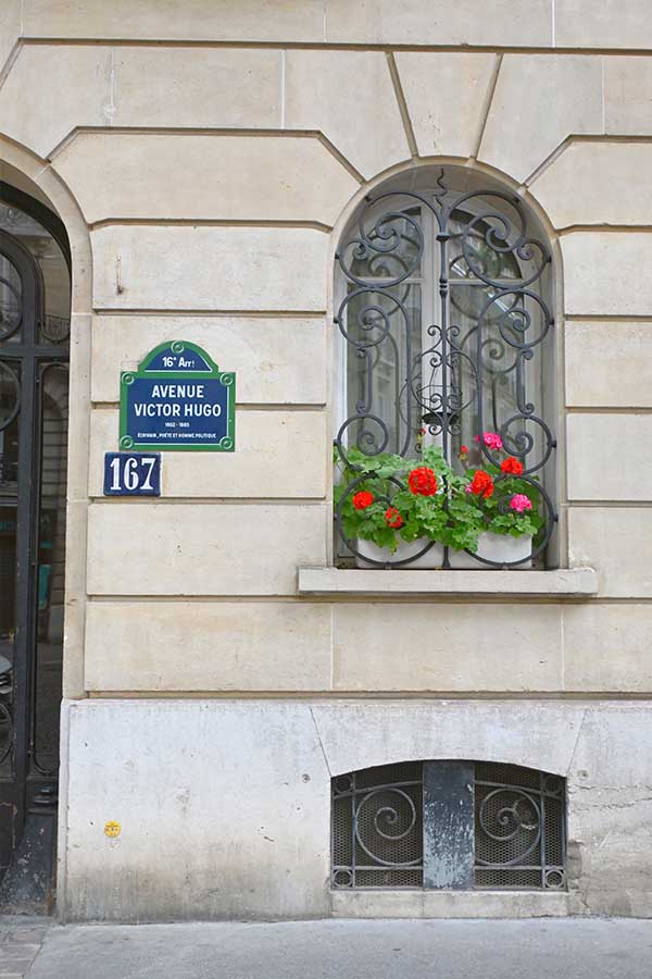 paris-france-avenue-victor-hugo-street-sign-and-arched-window-with-red-geraniums